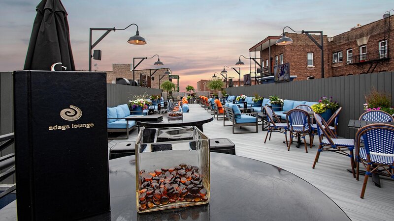 View of rooftop seating area with focus on Adega Lounge menu on table